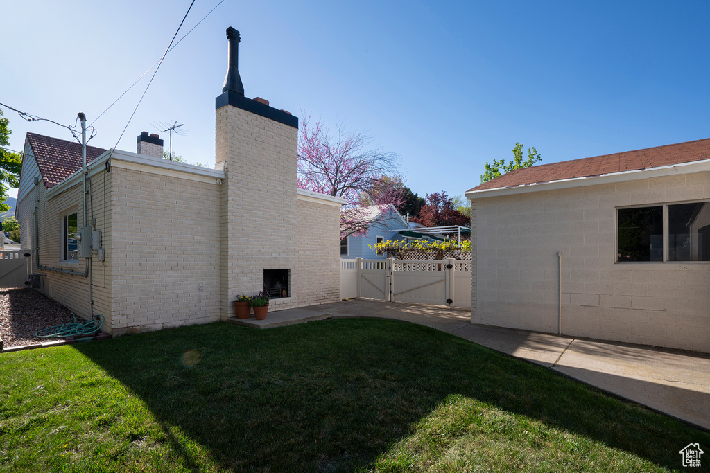 View of yard with fence, a gate, and a patio area