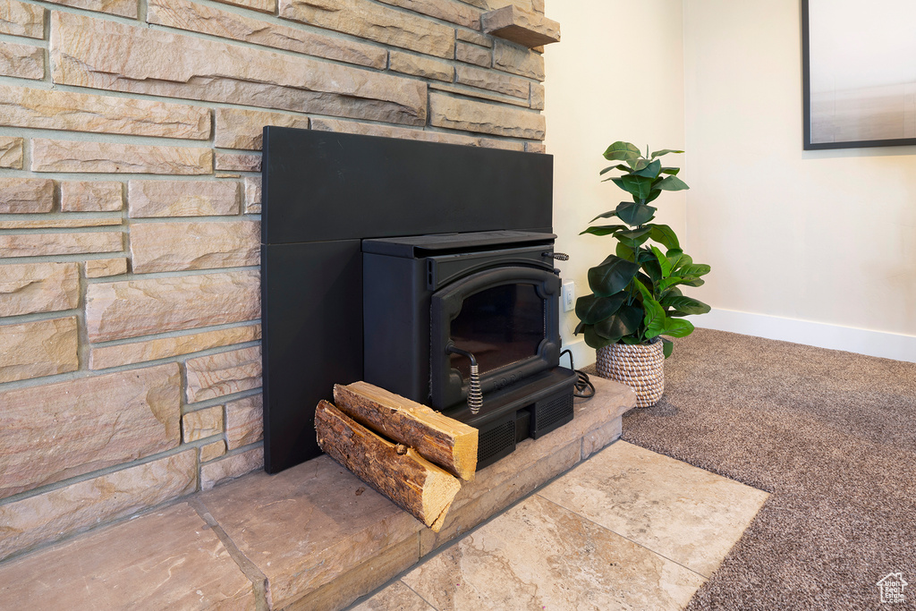 Details featuring baseboards, carpet, and a wood stove