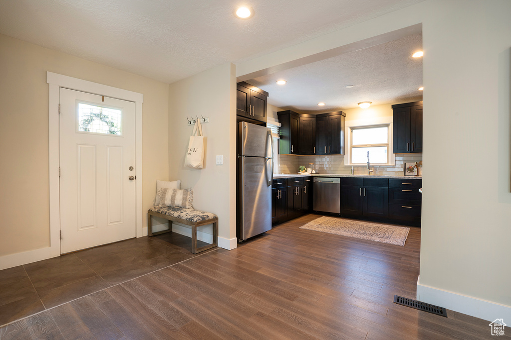 Kitchen with light countertops, backsplash, baseboards, and appliances with stainless steel finishes