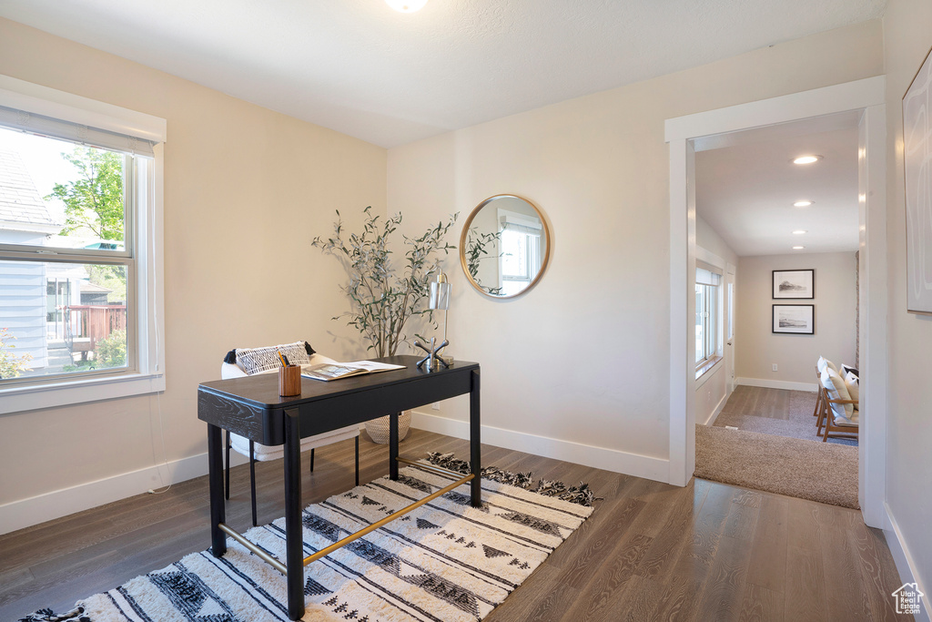 Office space with plenty of natural light, baseboards, and wood finished floors