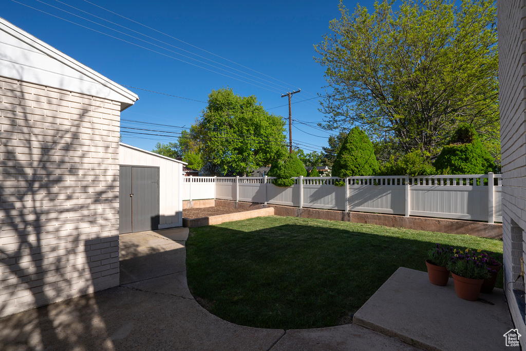 View of yard featuring a fenced backyard, an outbuilding, a patio area, and a storage shed