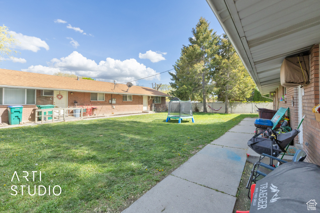 View of yard with a fenced backyard, a trampoline, and a patio area