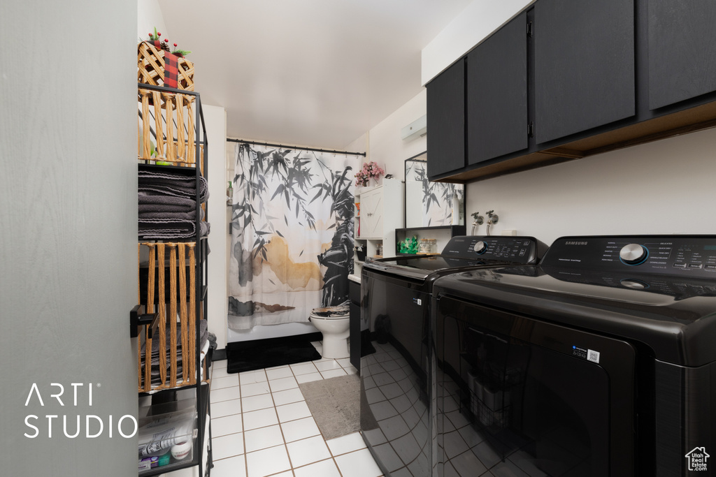 Laundry area with separate washer and dryer, cabinet space, and light tile patterned flooring