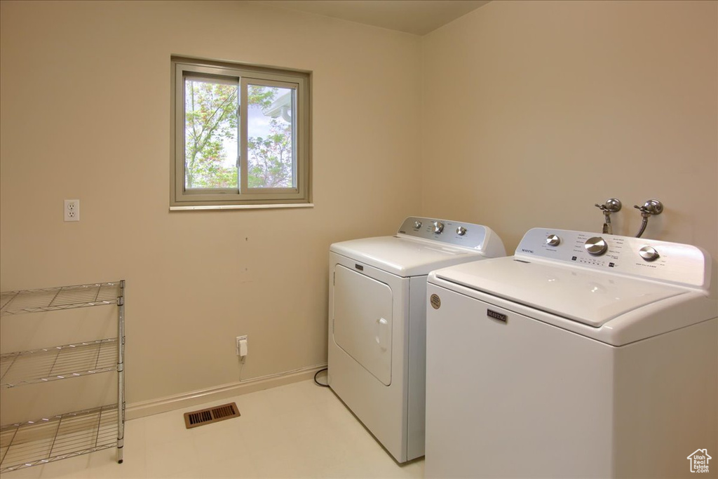 Laundry area with baseboards, laundry area, washing machine and dryer, and visible vents
