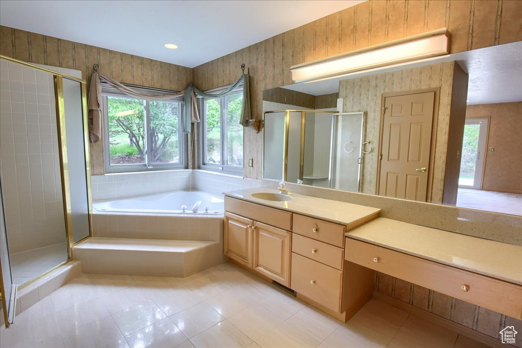 Bathroom with tile patterned floors, a shower stall, a bath, and vanity
