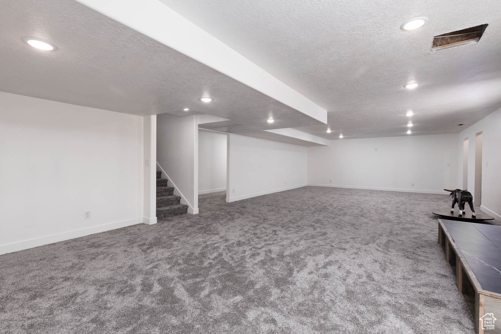 Finished basement featuring stairway, carpet flooring, recessed lighting, and a textured ceiling