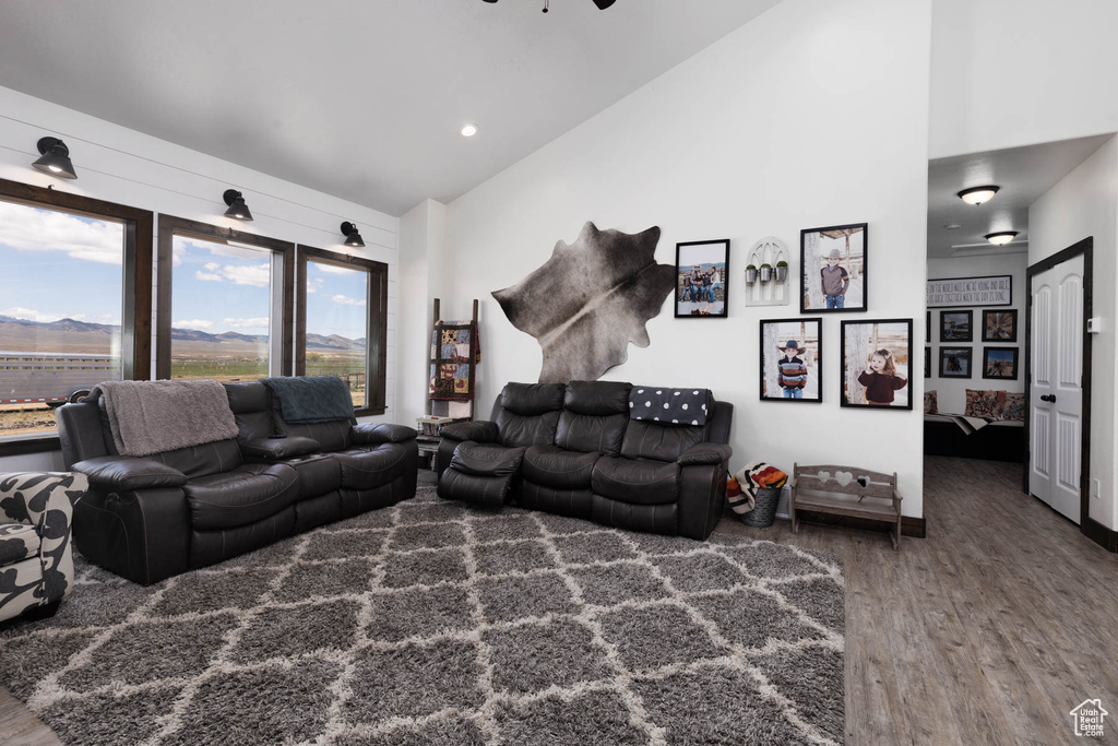 Living room featuring high vaulted ceiling, a healthy amount of sunlight, and wood finished floors