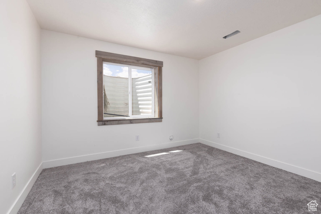 Spare room featuring baseboards and carpet