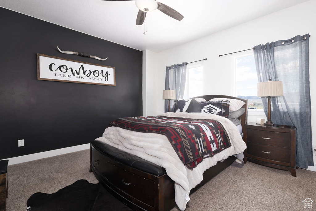 Carpeted bedroom with a ceiling fan