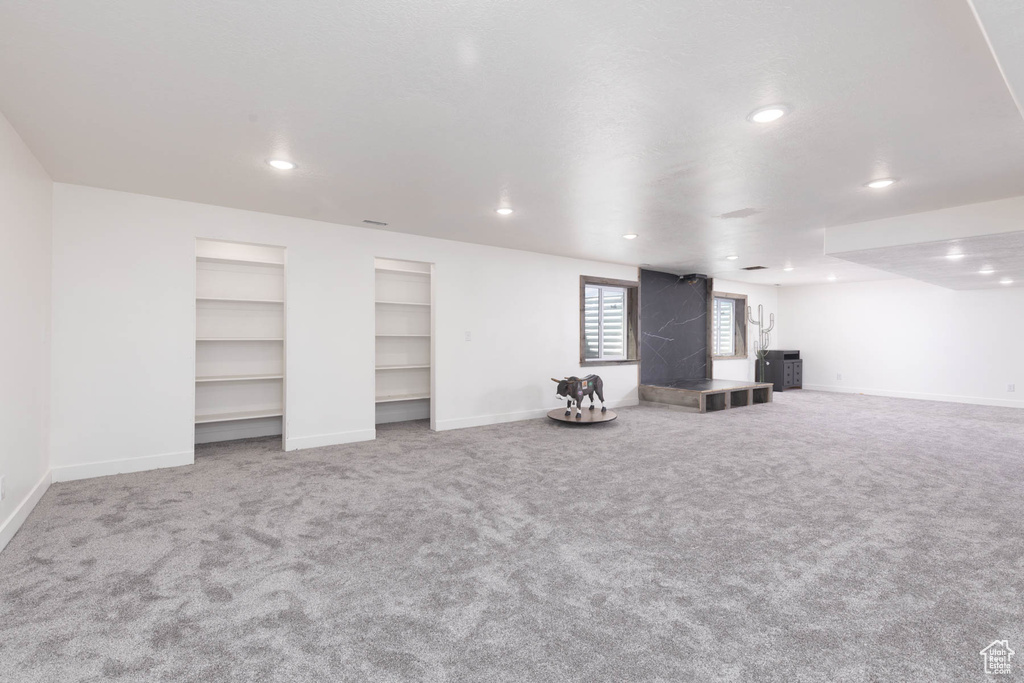 Basement with carpet floors, recessed lighting, baseboards, and built in features
