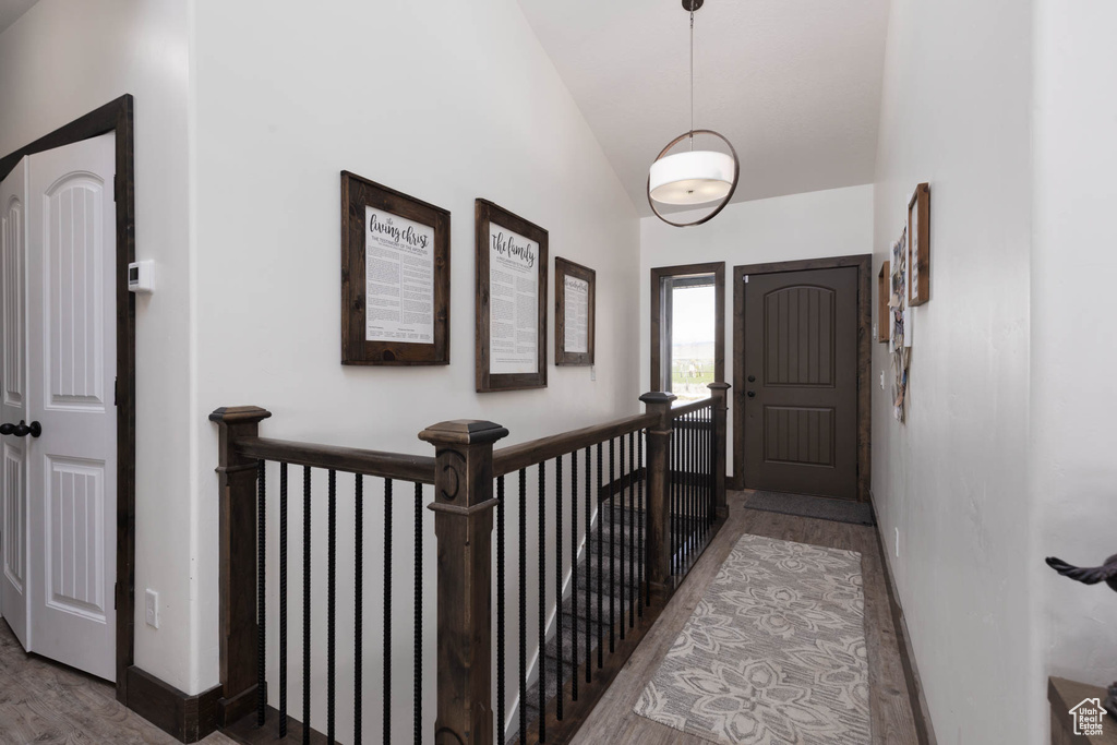 Entrance foyer with baseboards, vaulted ceiling, and wood finished floors