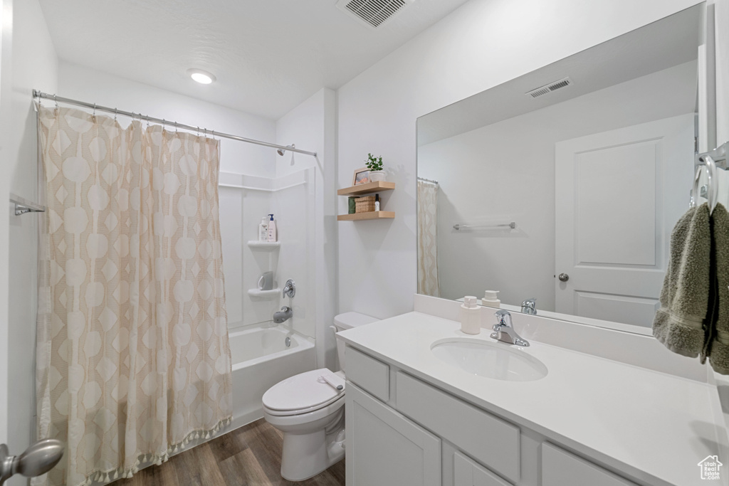 Bathroom featuring visible vents, wood finished floors, toilet, and vanity