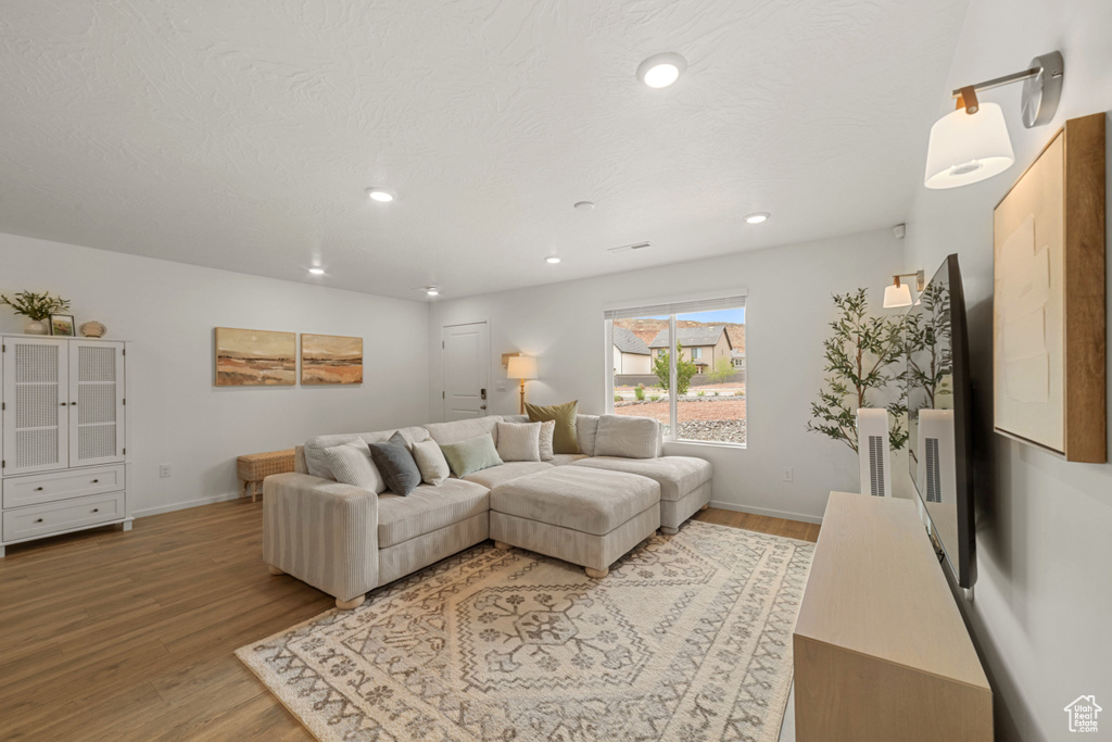 Living room featuring recessed lighting, baseboards, light wood-type flooring, and visible vents