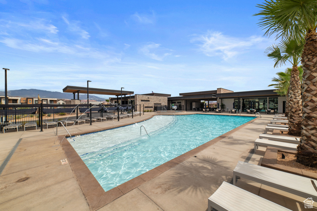 Pool with a patio, a mountain view, and fence