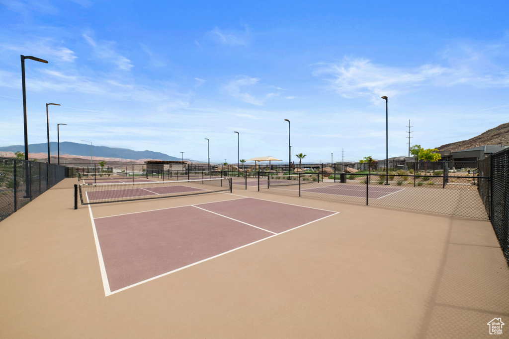 View of sport court featuring fence and a mountain view