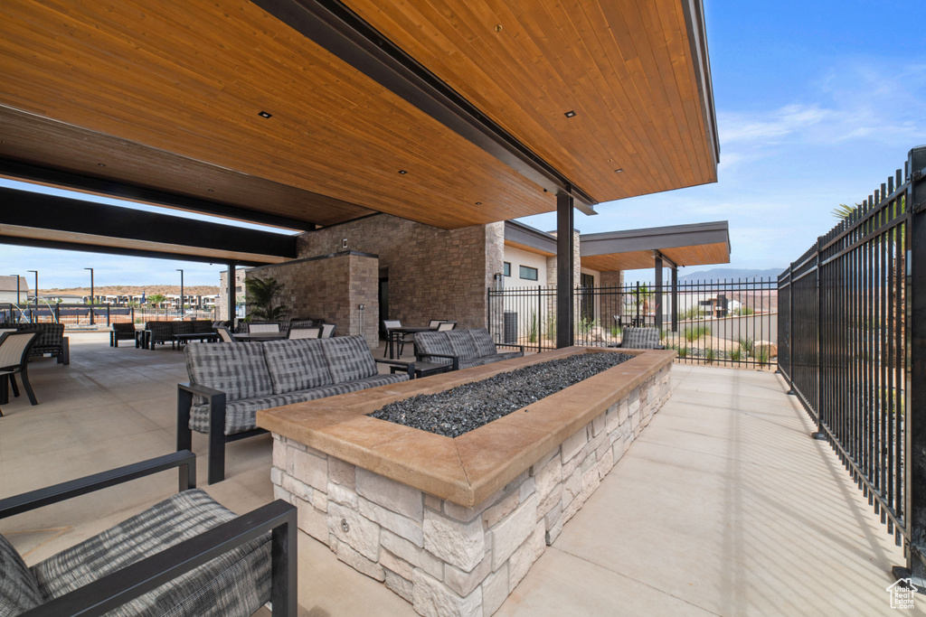 View of patio / terrace featuring fence and an outdoor living space with a fire pit