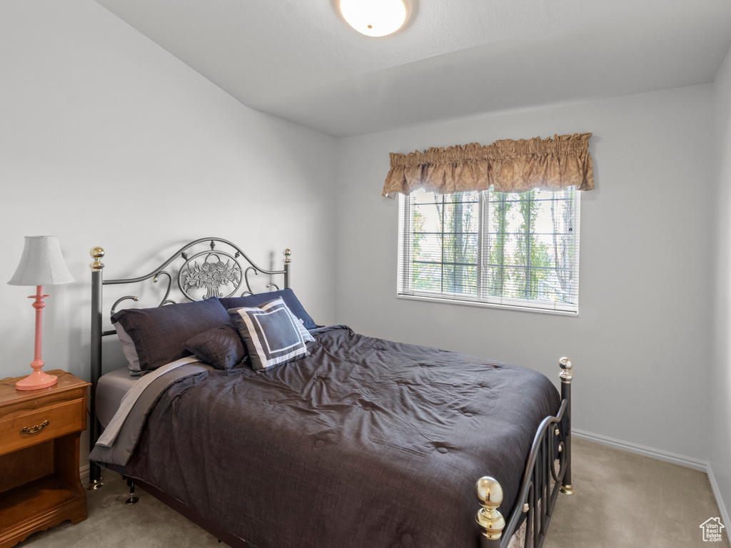 Bedroom with light colored carpet and baseboards