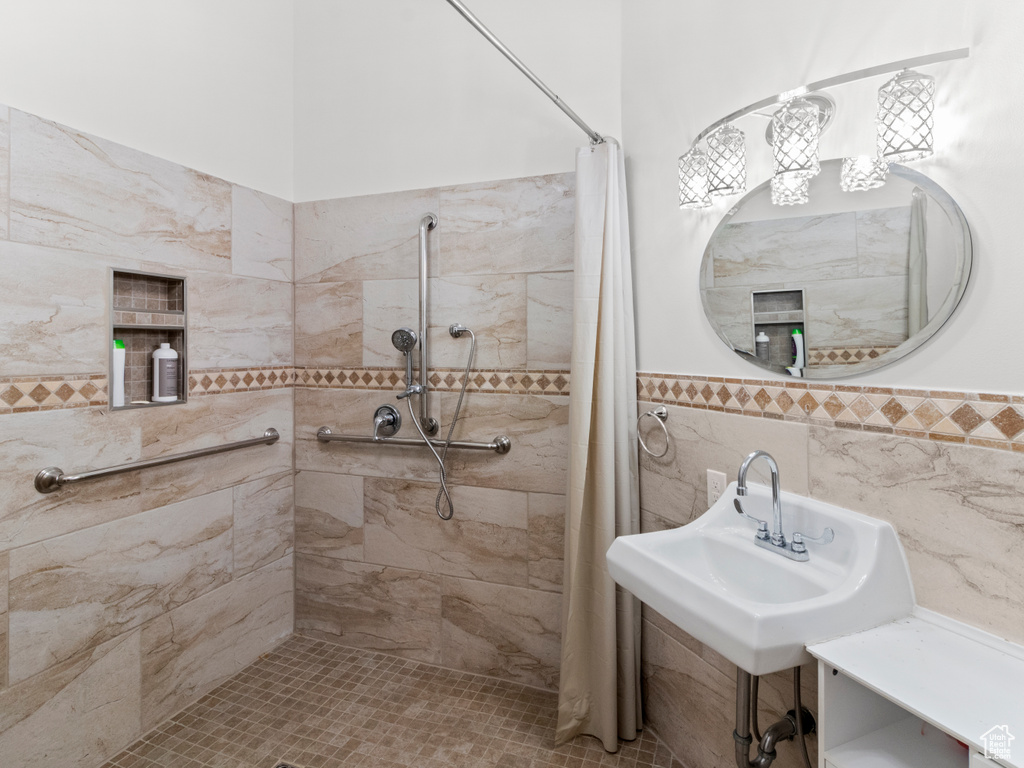 Bathroom with wainscoting and a tile shower