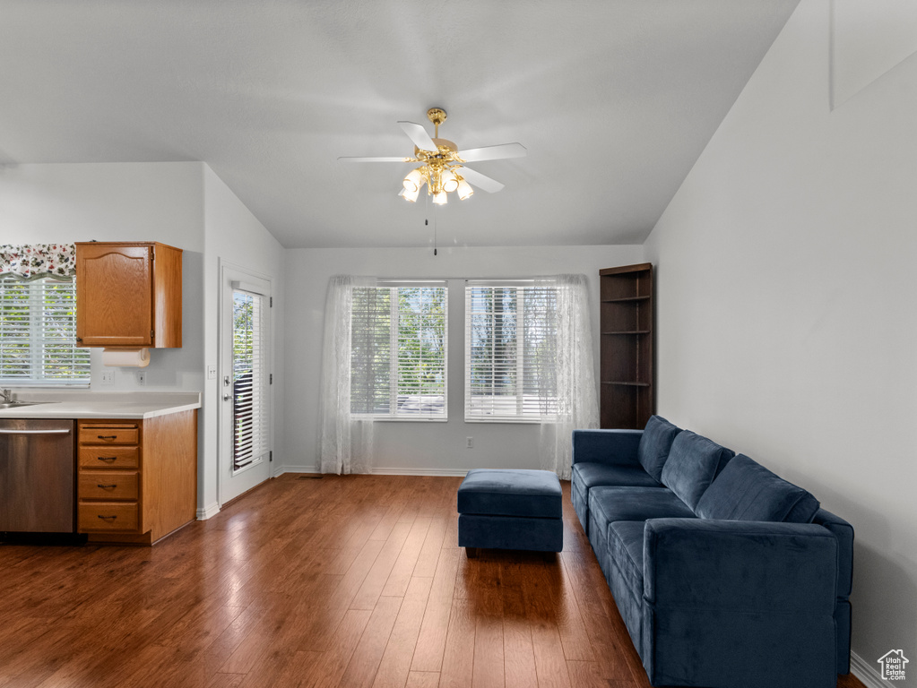 Living area with baseboards, a ceiling fan, dark wood-style flooring, and lofted ceiling