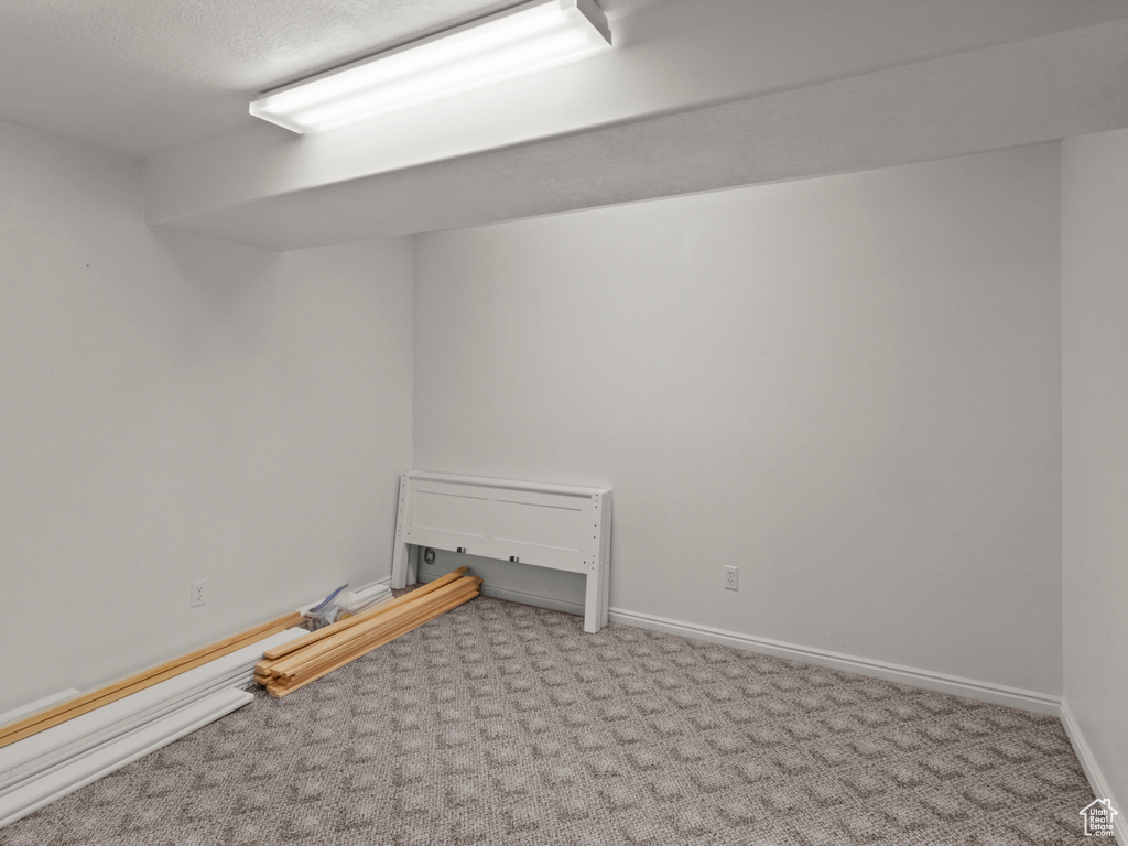 Finished basement with baseboards and carpet