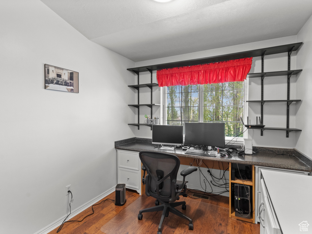 Home office with baseboards and dark wood-type flooring