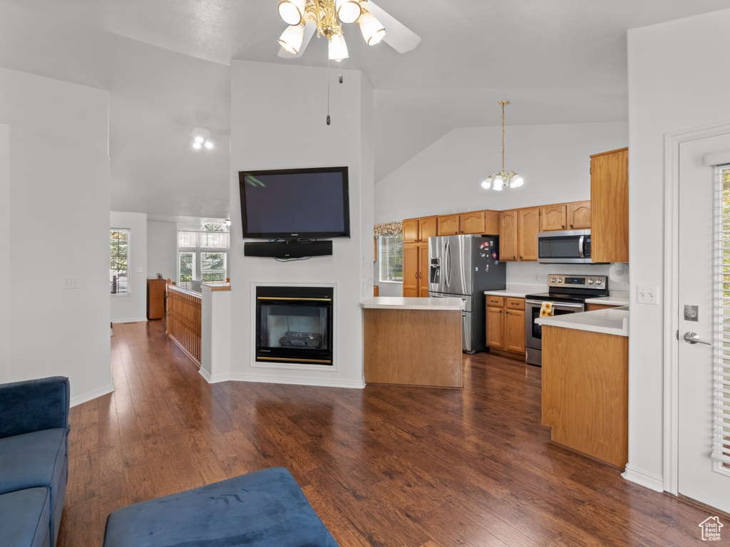 Kitchen featuring open floor plan, ceiling fan, high vaulted ceiling, light countertops, and stainless steel appliances