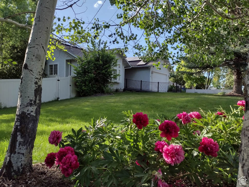 View of yard featuring fence and a garage