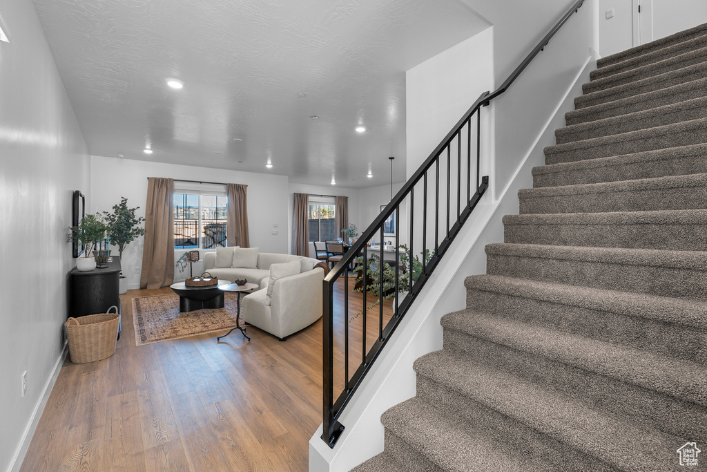 Stairway featuring recessed lighting, baseboards, and wood finished floors