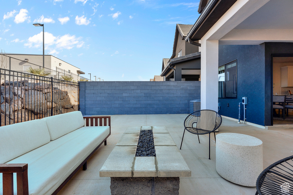 View of patio / terrace with central AC unit, a fenced backyard, and an outdoor living space with a fire pit