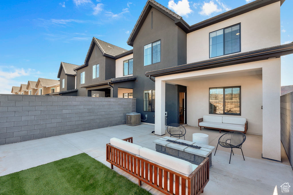 Rear view of property with stucco siding, a patio area, and outdoor lounge area