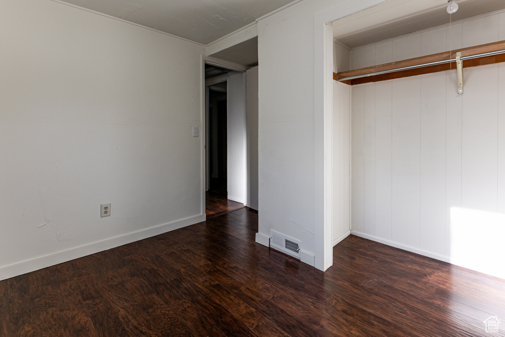 Unfurnished bedroom with visible vents, baseboards, and wood finished floors