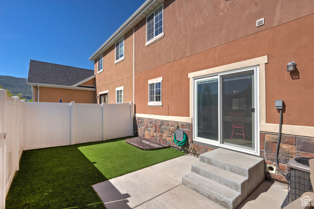View of yard with fence, entry steps, and a patio area