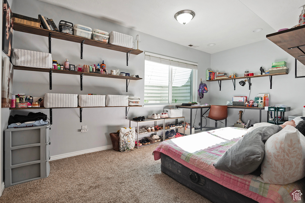 Carpeted bedroom featuring baseboards and visible vents