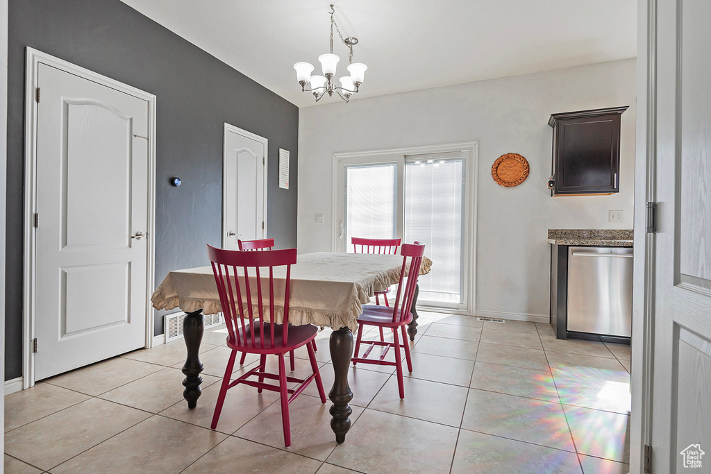 Dining space featuring light tile patterned floors, baseboards, and a chandelier