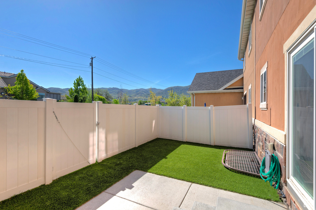 View of yard featuring a fenced backyard, a mountain view, and a patio
