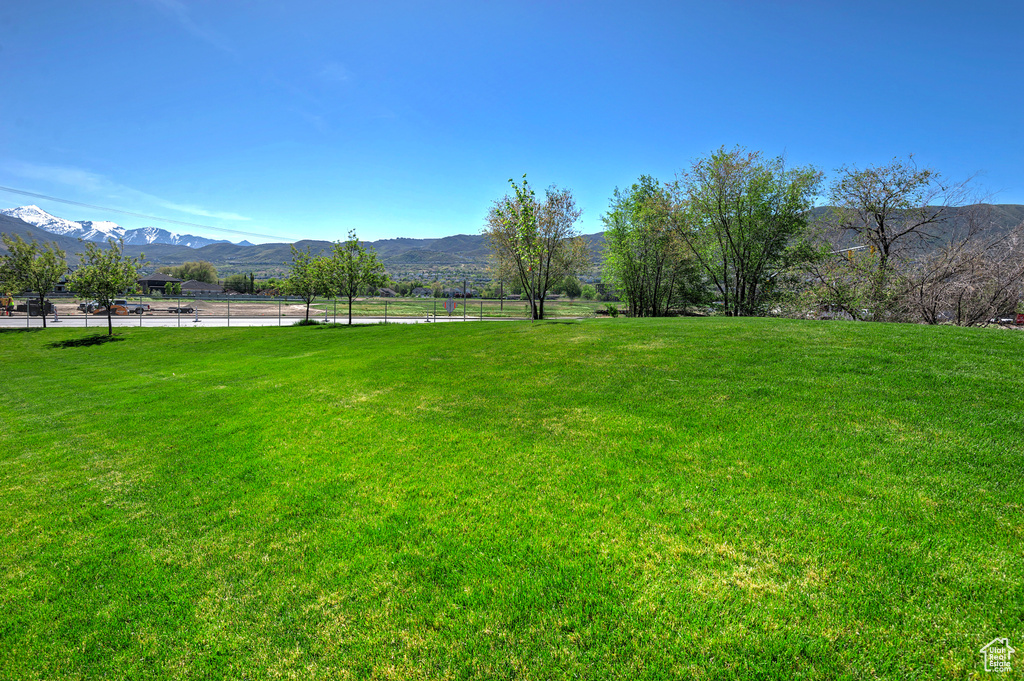 View of yard with fence, a mountain view, and a rural view