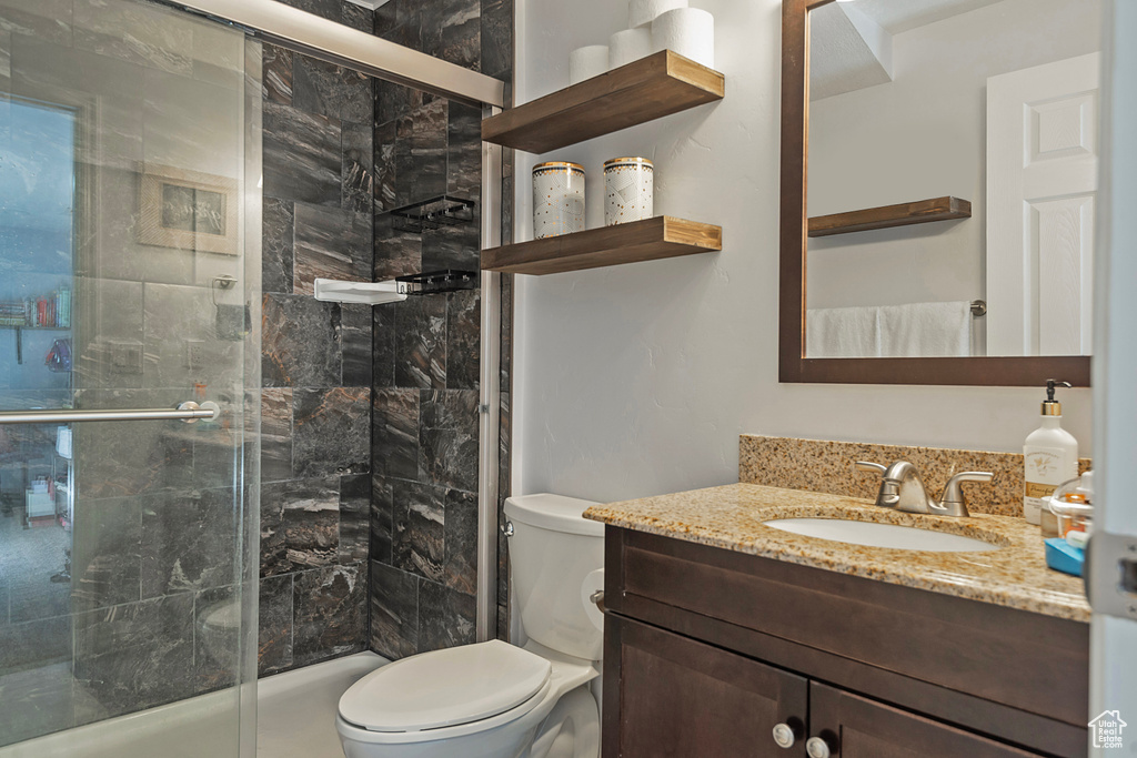 Full bath with vanity, toilet, and a stall shower