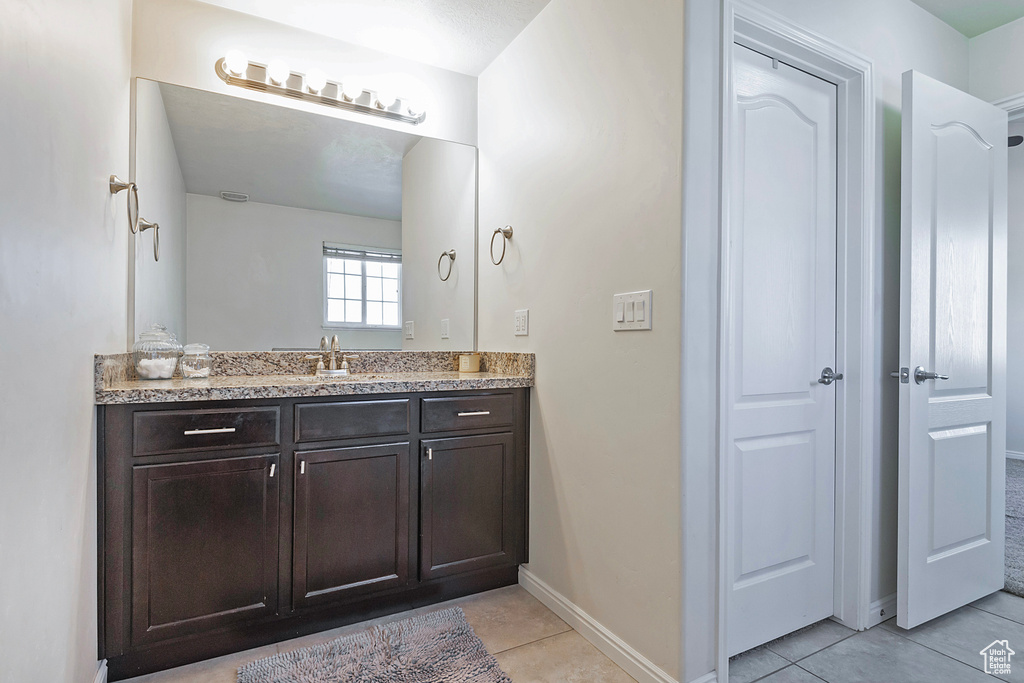 Bathroom with tile patterned floors, baseboards, and vanity