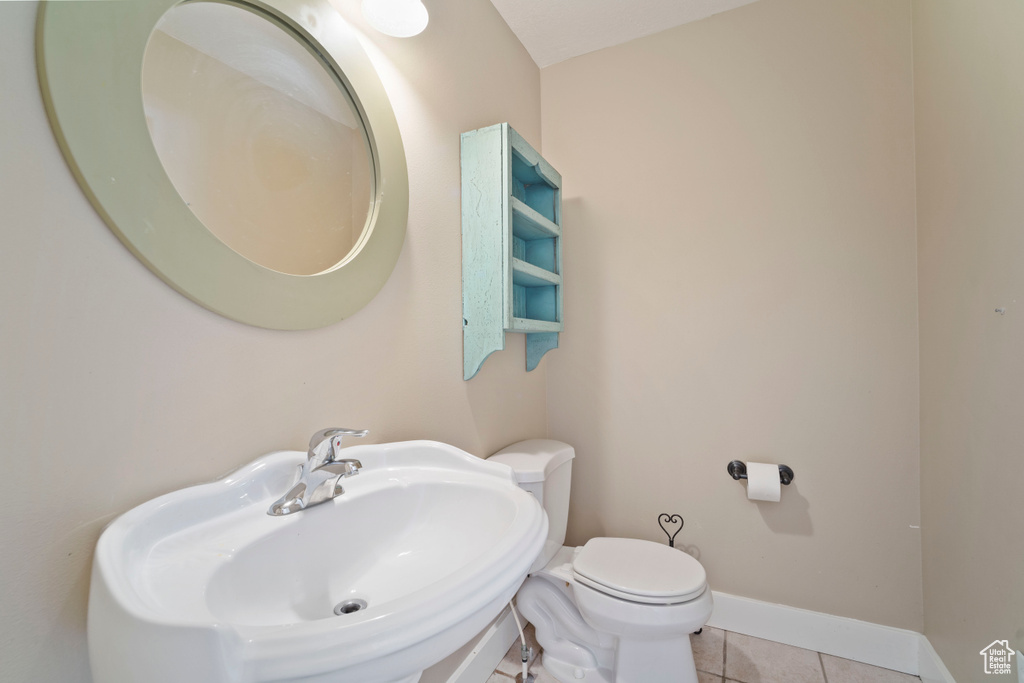 Bathroom with a sink, tile patterned floors, baseboards, and toilet