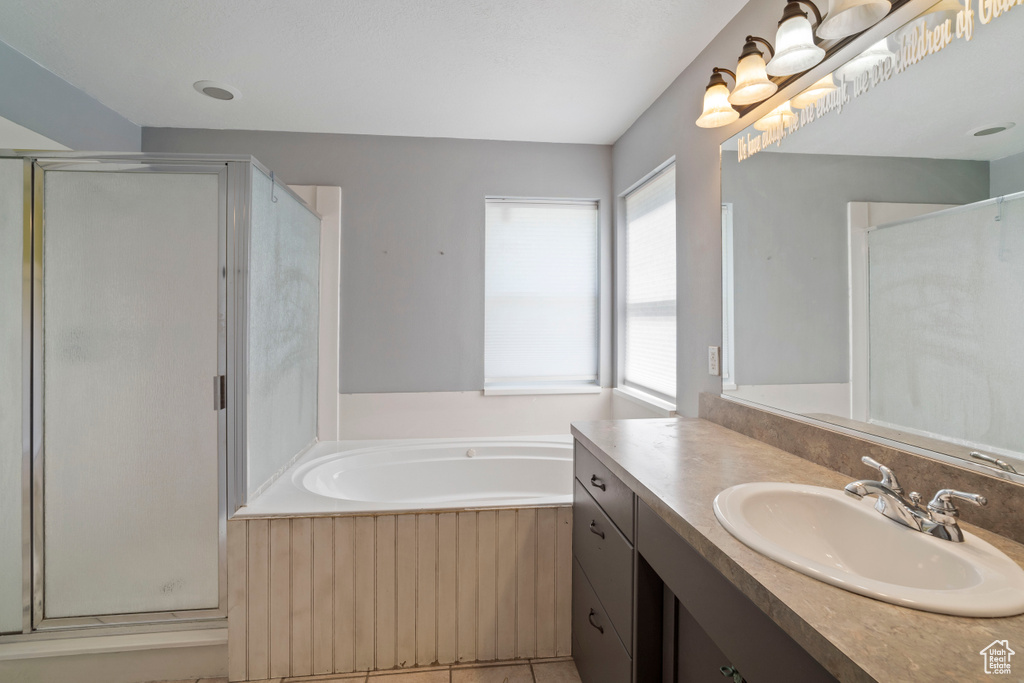 Full bath featuring a shower stall, a bath, and vanity