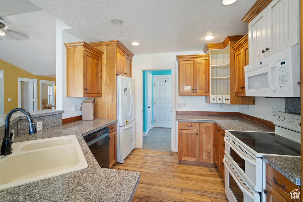 Kitchen featuring open shelves, white appliances, ceiling fan, a sink, and light wood-style flooring