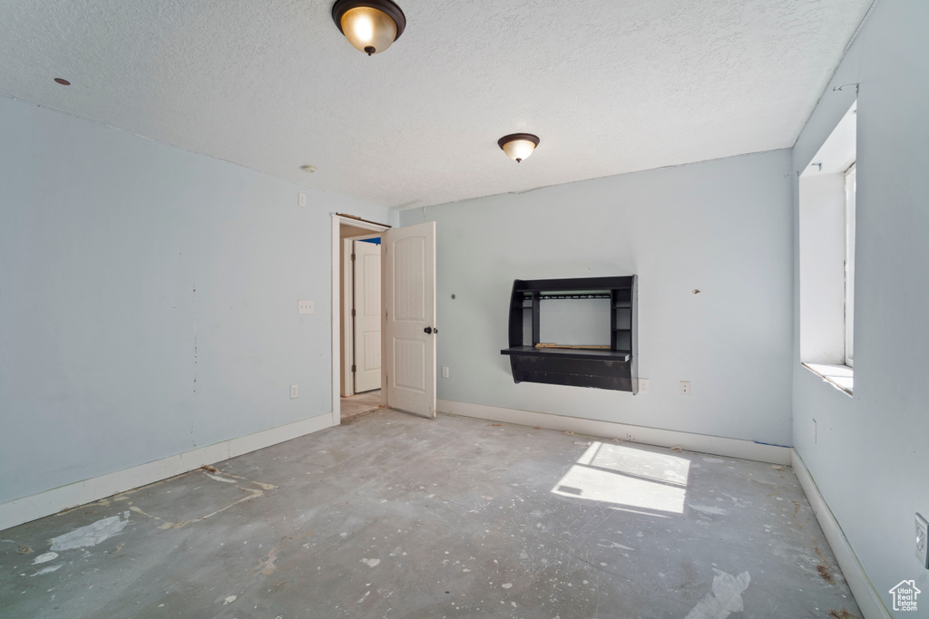 Interior space with baseboards and a textured ceiling