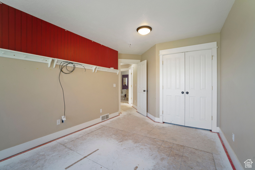 Unfurnished bedroom featuring baseboards, visible vents, and a closet