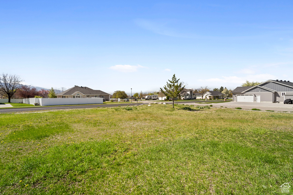 View of yard featuring fence, driveway, and a residential view