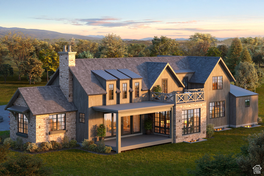 Back of house at dusk with french doors, a chimney, a patio area, a yard, and stone siding