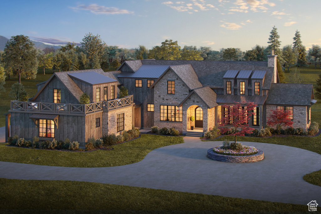View of front of property featuring stone siding, a standing seam roof, a chimney, a lawn, and metal roof