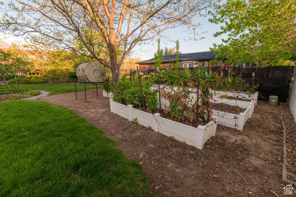 View of yard featuring fence and a vegetable garden