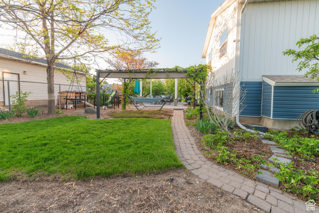 View of yard with a patio, a playground, and fence
