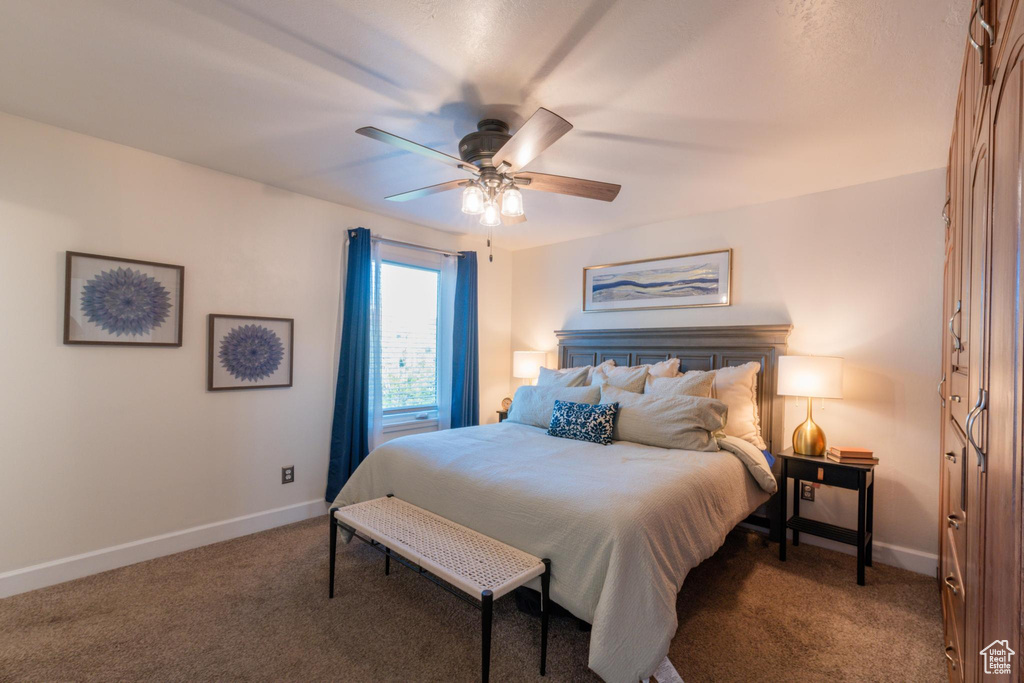 Carpeted bedroom featuring baseboards and a ceiling fan