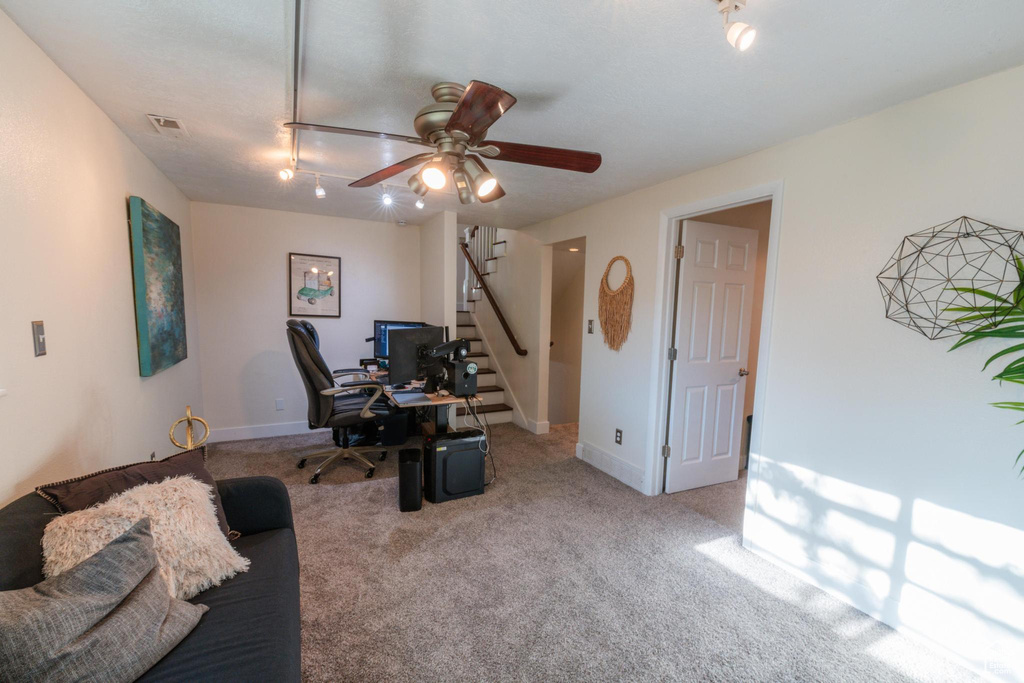 Home office featuring visible vents, carpet flooring, baseboards, and ceiling fan